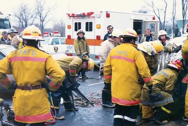 Firefighters extricating person trapped in crashed auto on Elmhurst Road