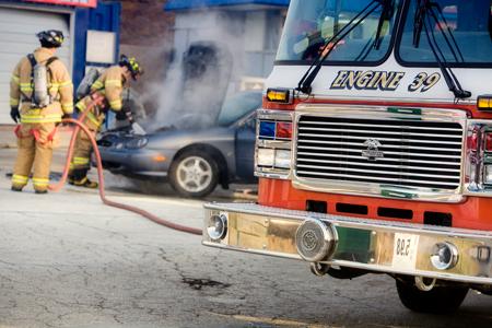 Firefighters extinguishing a car fire