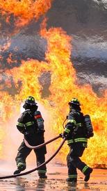 Prospect Heights firefighters operating a hose stream to combat an aircraft fuel fire