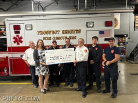 Prospect Heights firefighters accepting bug check from Illinois American Water representative