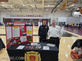 PHFD booth at Skilled Trades Fair. Firefighter Wozniak on left, Lieutenant Rill on right